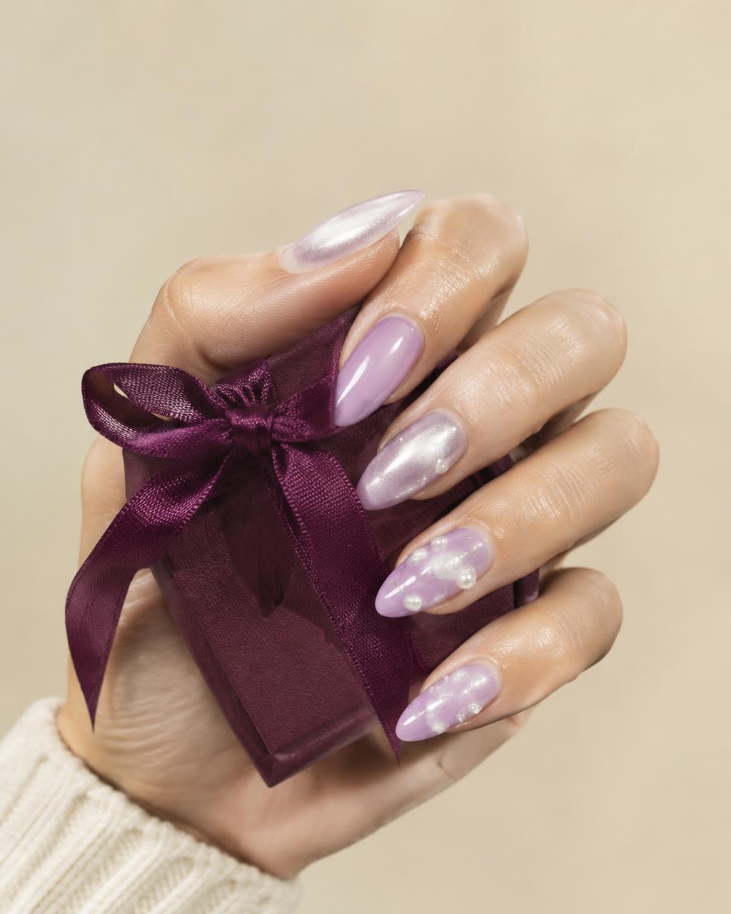 Lavender and pearl press-on nails holding a plum gift box